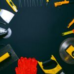 A collection of hand tools laid out on a dark surface, perfect for construction themes.