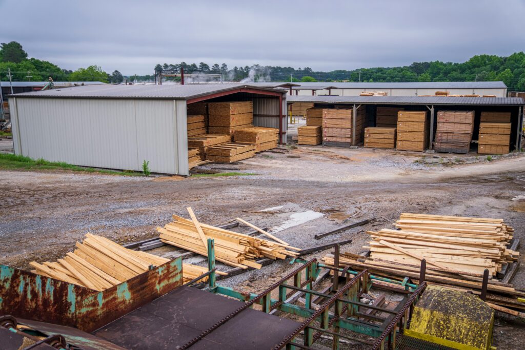 A comprehensive view of an industrial lumber yard showcasing neatly stacked wood planks ready for distribution.