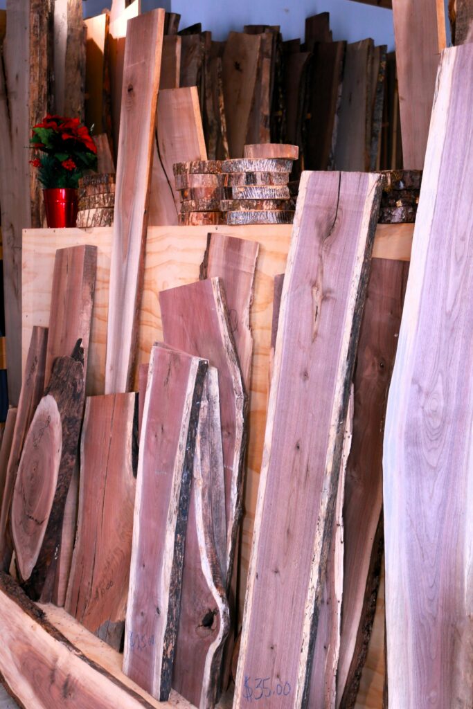 Various wooden planks and slices displayed in a carpentry workshop.